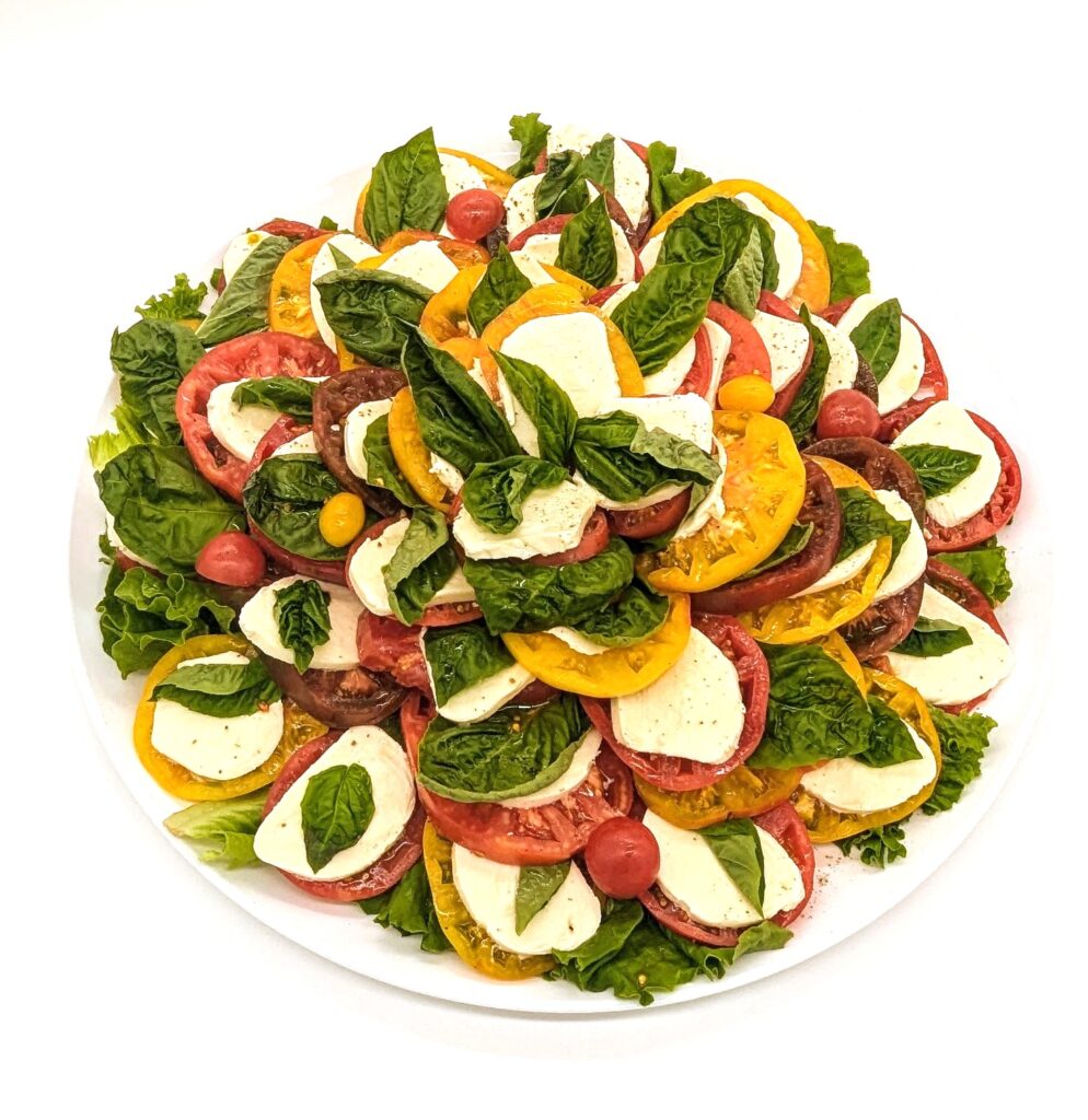 Caprese platter with sliced tomatoes, fresh mozzarella and basil