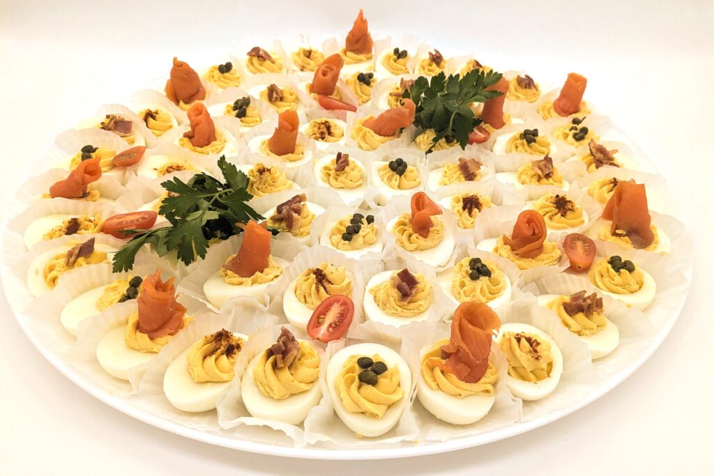 Assorted deviled eggs platter topped with bacon, lox, capers and tradiational