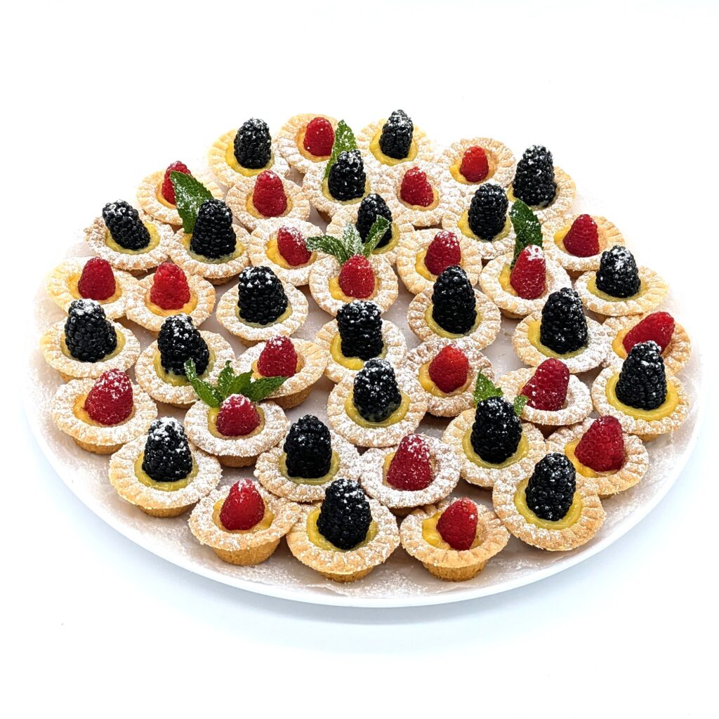 Little lemon tarts platter  topped with a fresh blackberry or a raspberry